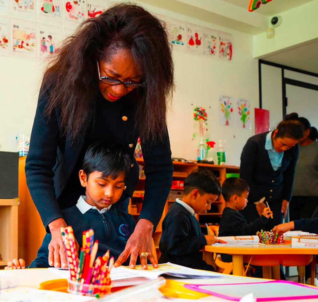 Enseignante accompagnant un enfant en classe à l’école bilingue Open Sky International (92)