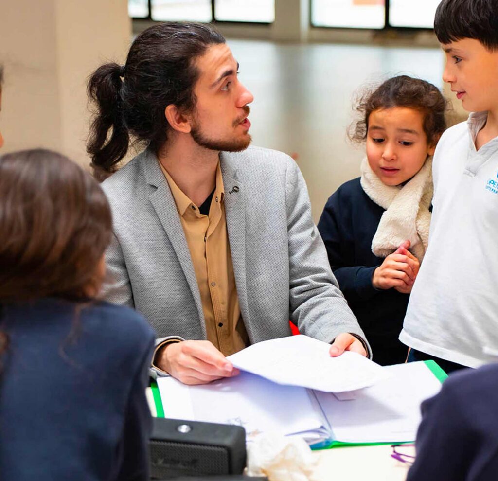 Enseignant accompagnant des élèves de primaire en immersion anglais-français à Open Sky International
