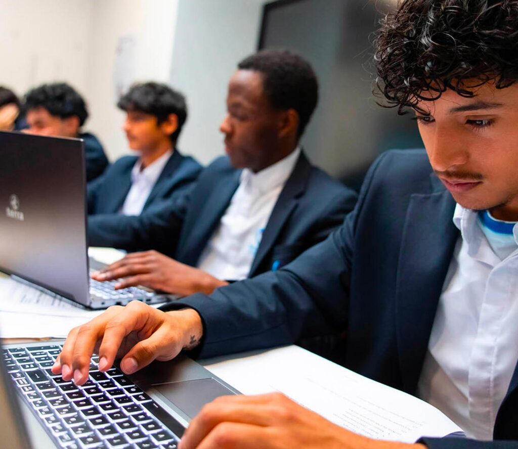 Élèves en cours d’informatique sur ordinateurs portables à Open Sky International